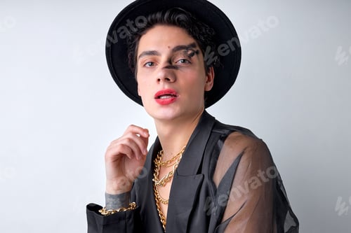 Preview: Sexy womanlike male in black translucent shirt and hat, with make-up posing at camera