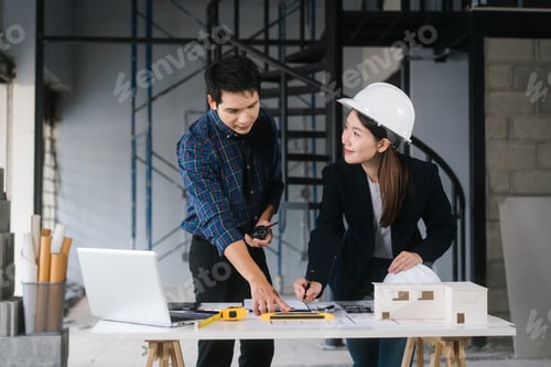 Preview: Asian couple reviews architectural plans together renovation site They collaborate ideas remodel
