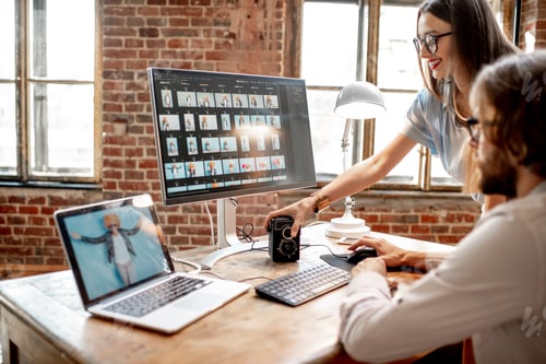 Preview: Couple of photographers working on computers in the studio
