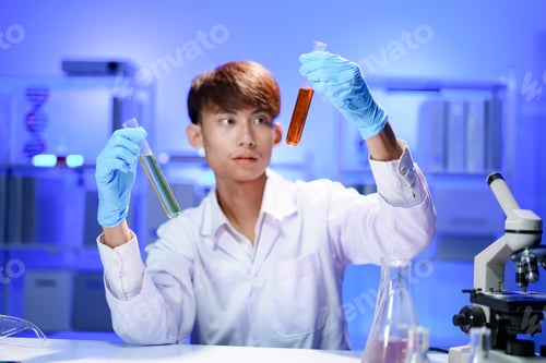 Preview: A young male scientist examining a test tube in a lab.