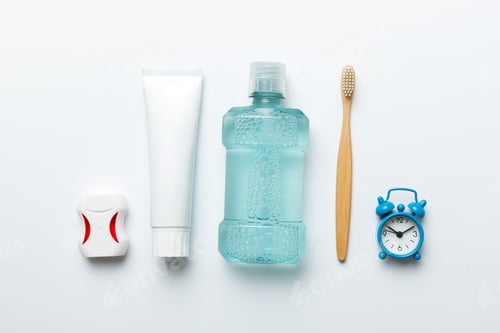 Preview: Mouthwash and other oral hygiene products on colored table top view with copy space.