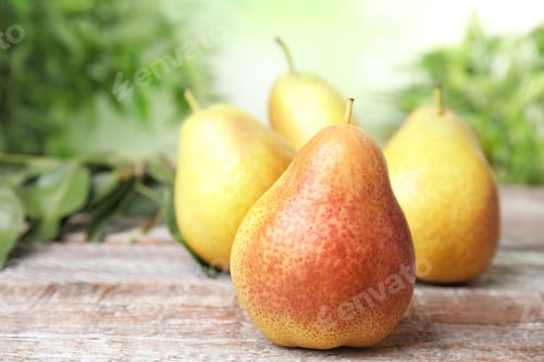 Preview: Ripe juicy pears on brown wooden table against blurred background. Space for text