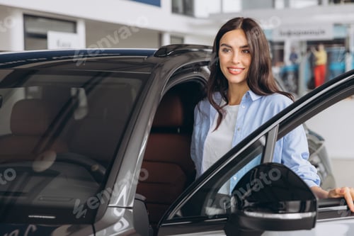 Preview: Happy friendly woman customer buyer client wears blue shirt stand inside car dealership chooses auto