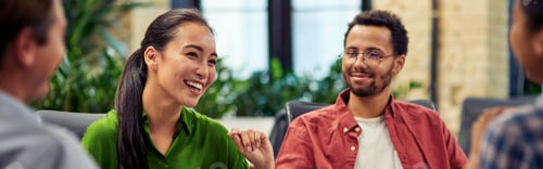 Preview: Young cheerful asian business woman discussing project results with colleagues while working