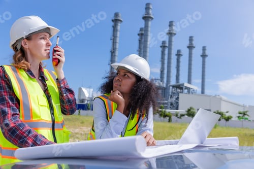Preview: Female Engineers in Safety Gear Discussing Project Plans.