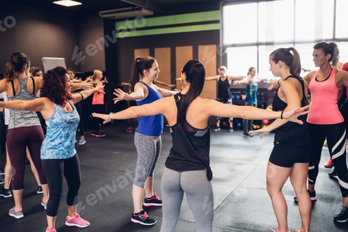 Preview: Group of women training in gym, with arms outstretched