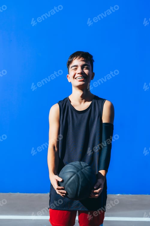 Preview: Portrait of a smiling man holding a basket ball looking at camera.