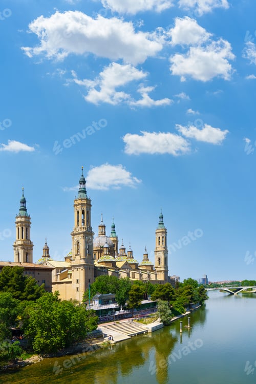 Preview: Basilica del Pilar reflecting on ebro river under blue sky in zaragoza