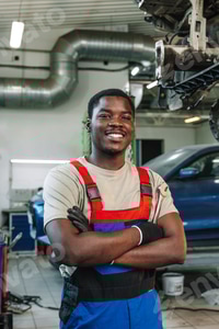 Preview: Portrait of young african man car service worker wearing uniform standing in garage