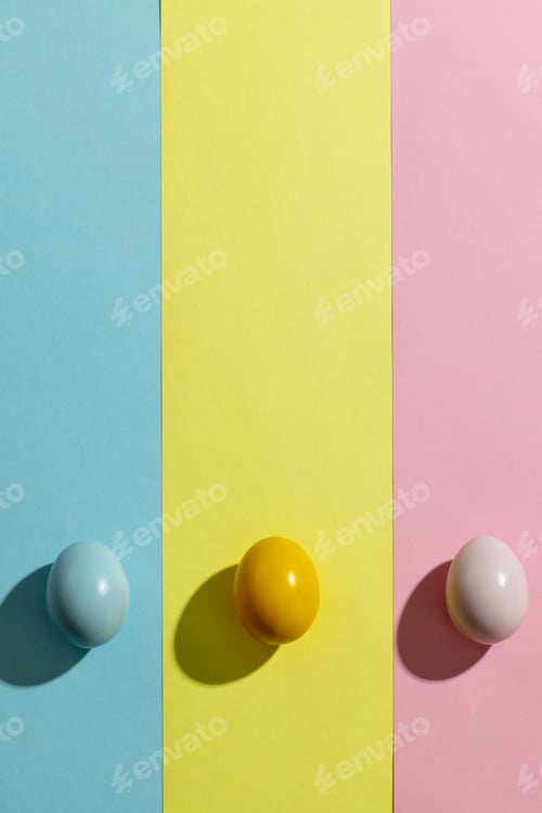 Preview: Image of yellow, pink and blue easter eggs and copy space on yellow, pink and blue background