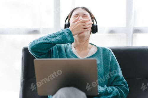 Preview: Smart and positive Asian female freelancer or student getting sleepy during online webinars or home