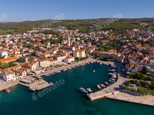 Preview: Aerial view of a charming coastal town with red roofs and a bustling harbor. Bol, Croatia