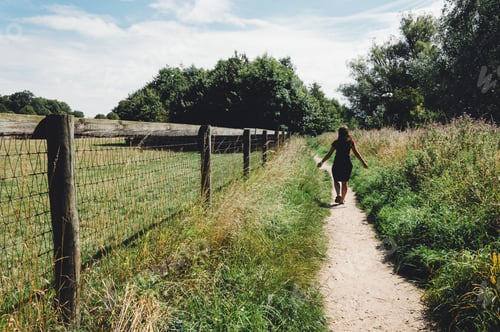 Preview: Girl walking on a path along a fence