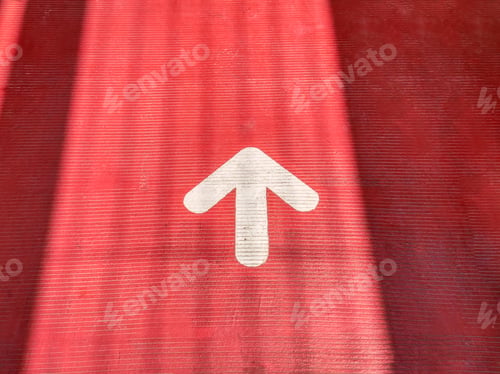 Preview: High Angle View of White Traffic Arrow on Red Street