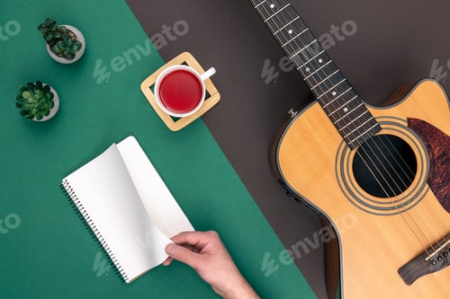 Preview: Flat lay, acoustic guitar and notebook on color background.