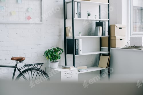Preview: bicycle and shelves with folders in light modern office