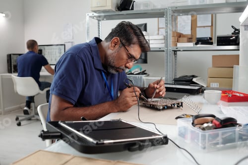 Preview: Man Working on Electronics at Modern Office Desk