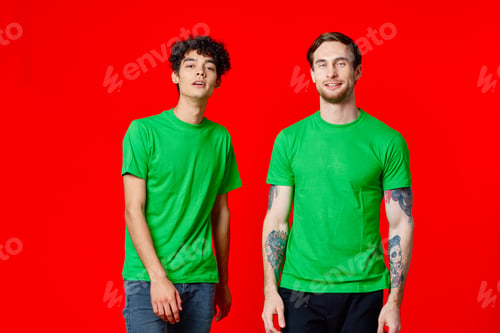Preview: two friends in green t-shirts communication lifestyle red background