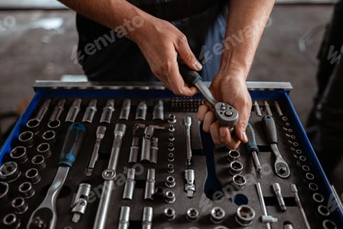 Preview: Skilled mechanic organizing tools in workshop for efficient repairs and maintenance tasks