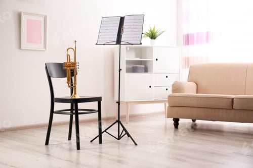Preview: Trumpet, chair and note stand with music sheets in room