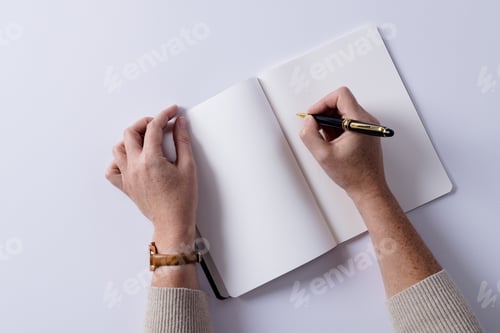 Preview: Hands of caucasian woman holding pen and writing in notebook with copy space on white background