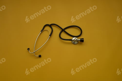 Preview: Top shot of stethoscope on ocher background - health check up concept