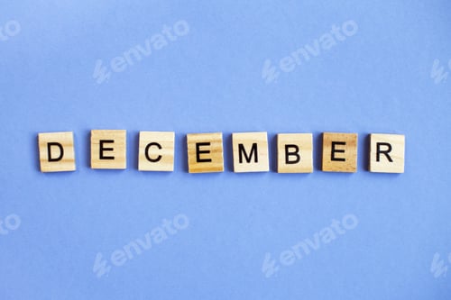 Preview: inscription December made by wooden cubes on a veri peri purple background.