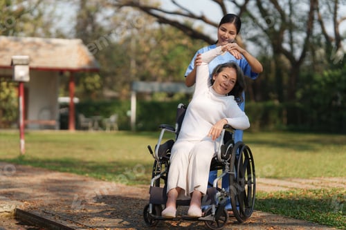 Preview: Elderly asian senior woman on wheelchair with nurse. Nursing home hospital garden concept