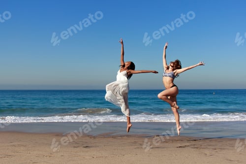 Preview: Two young female dancers leaping mid air on beach