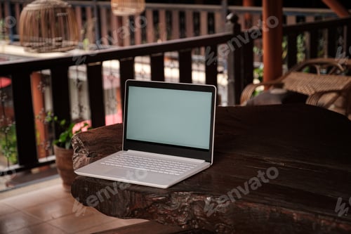 Preview: A white laptop on wooden table swiming pool background.
