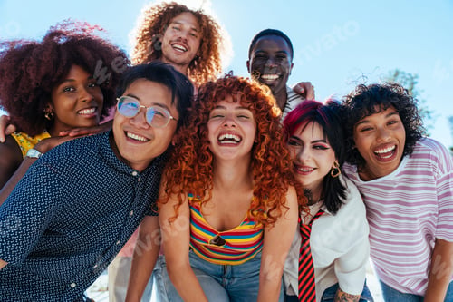 Preview: Multiethnic group of young friends meeting and having fun outdoors