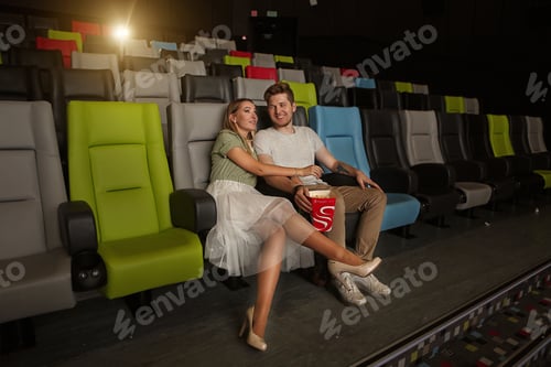 Preview: a guy and a girl watch a movie in a cinema, hug and eat popcorn