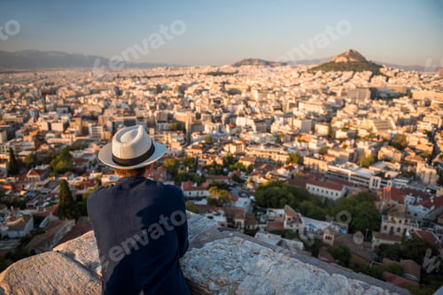 Preview: Tourist man looking at view over Athens from Likavitos Hill on summer holiday, at The Acropolis, Att