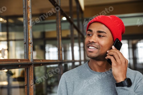 Preview: Image of young african american man talking on cellphone in office
