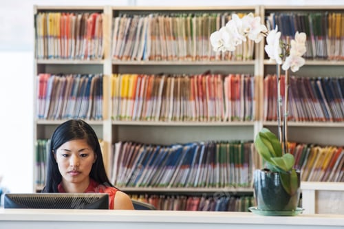 Preview: Asian female working in a medical office with file folders in the background