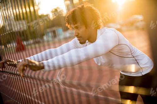 Preview: Young man stretching during outdoor training