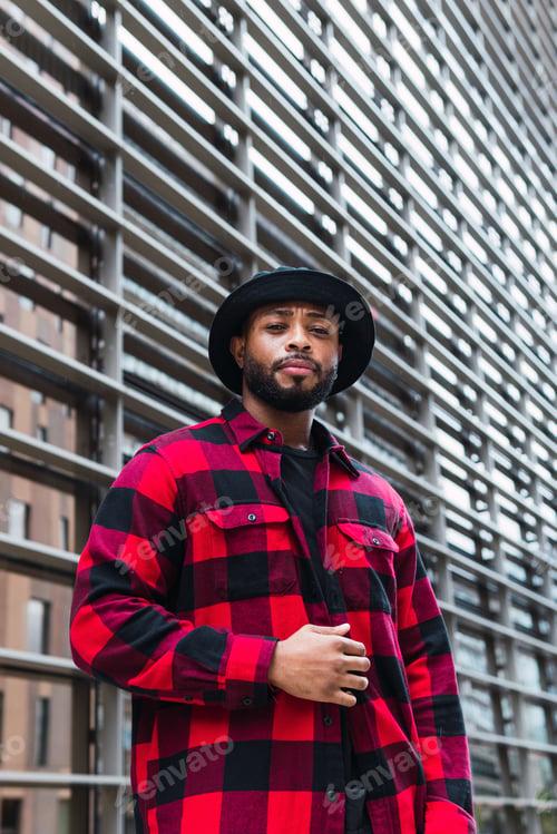 Preview: Fashion portrait, cool and black man posing in a city glass building