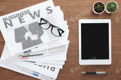 Preview: elevated view of potted plants, pen, tablet with blank screen and business newspapers on wooden