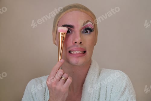 Preview: Half man half woman make up person. Drag queen person with a make-up brush.