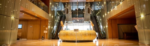 Preview: modern hotel interior with round reception desk and sophisticated lobby design, escalators, moving