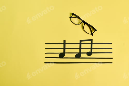 Preview: A pair of eyeglasses and musical notes on a yellow background