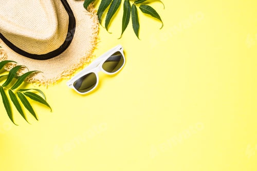Preview: Summer hat and sunglasses on yellow top view.