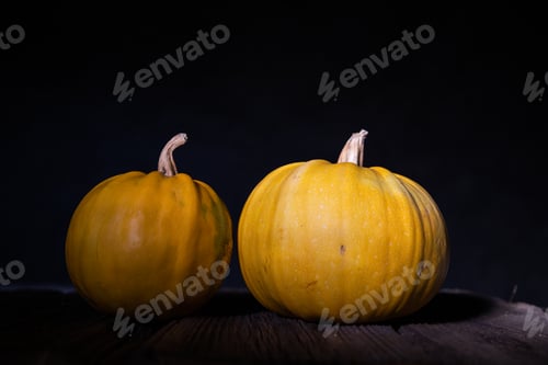 Preview: Two Yellow Pumpkins on a Dark Wooden Surface