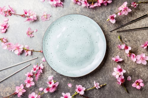 Preview: Chopsticks and sakura branches on gray stone background. Japanese food concept. Top view, copy space