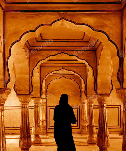 Preview: Rear view of woman walking along colonnade of ancient fortress.