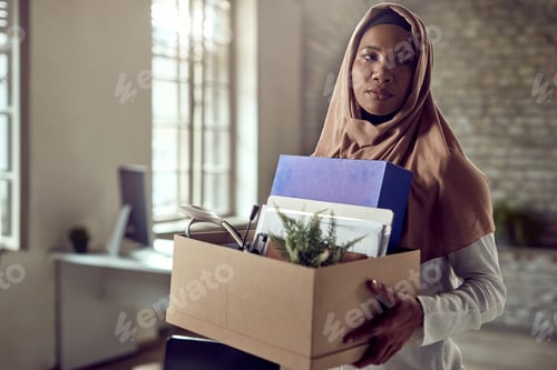 Preview: Pensive Muslin businesswoman carrying her belongings after losing a job.