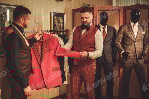 Preview: Men Choosing Stylish Suit in Upscale Tailor Shop