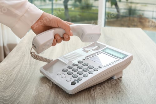 Preview: Woman using telephone at table indoors, closeup
