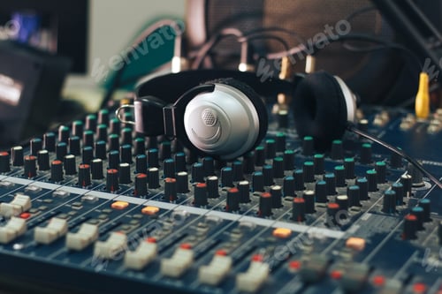 Preview: Silver headphones on a Studio audio mixer.