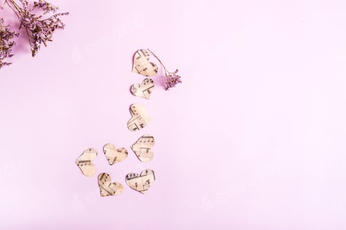 Preview: The concept of love for music. Musical note from paper hearts and dry flowers on a pink. Top view.